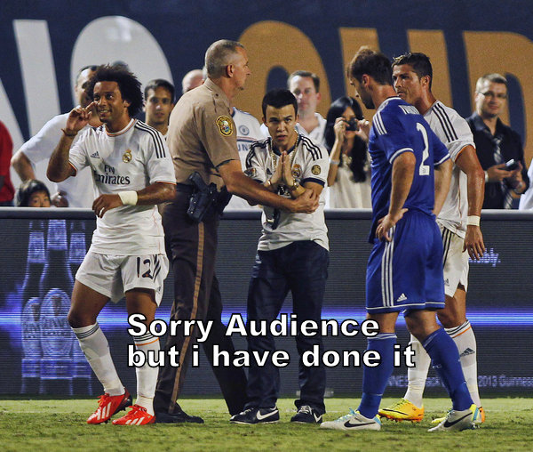Real Madrid's Marcelo walks past as a police officer removes a fan who entered the pitch to hug Ronaldo during regulation time against Chelsea in their Guinness International Champions final soccer match in Miami Gardens